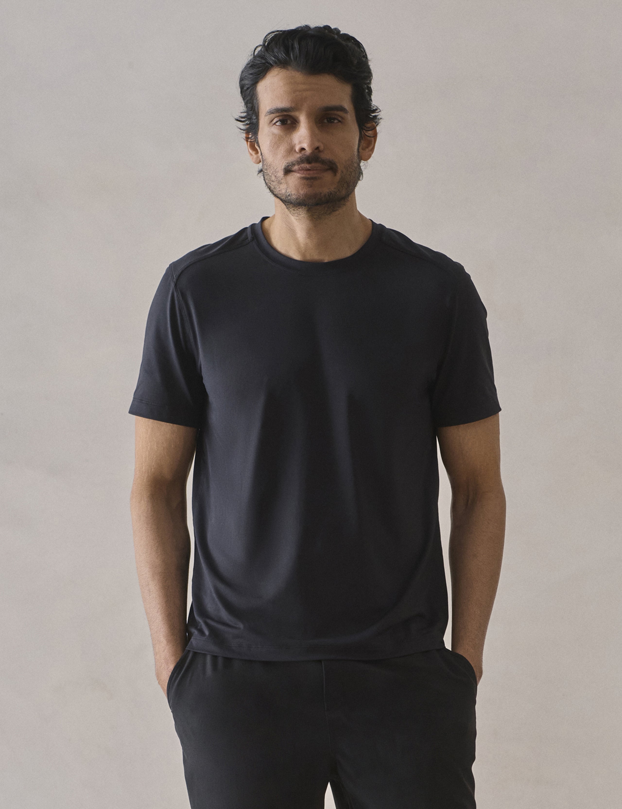 Front upper-body view of man wearing Adventure Performance Short-Sleeve Tee in Onyx Black from AETHER Apparel.
