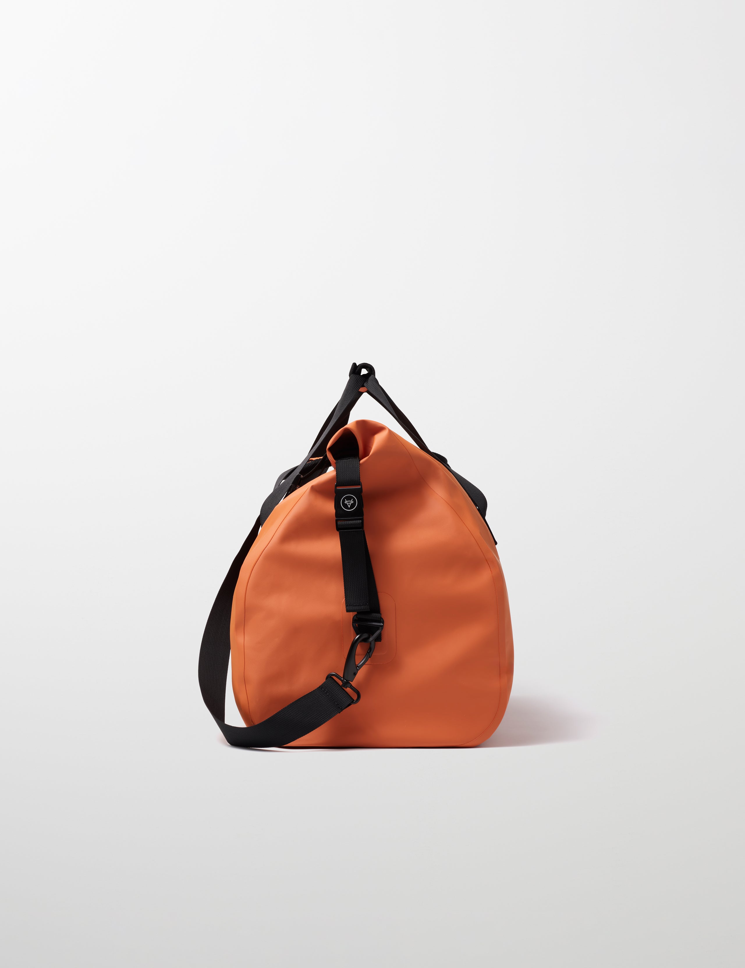 Side profile view of Excursion Duffle Bag 60L in Autumn Orange from AETHER Apparel.