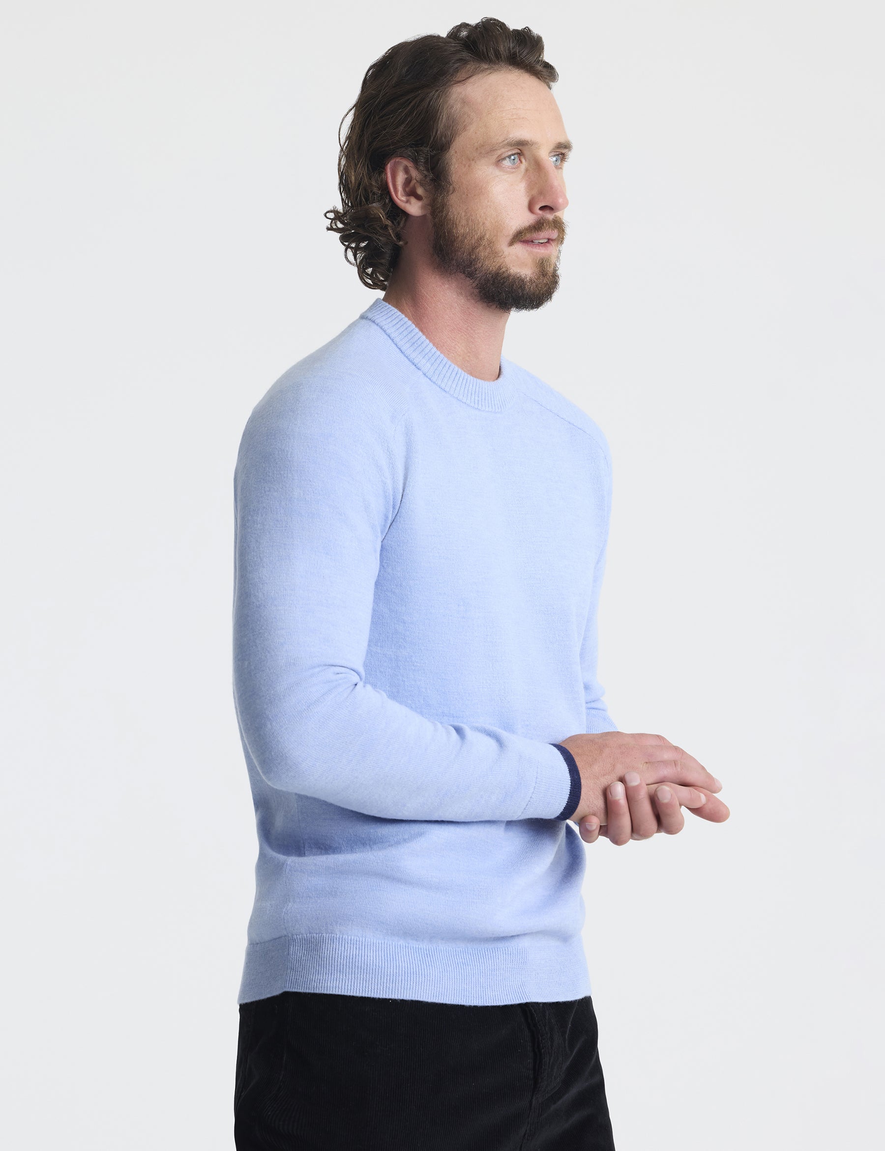 Angled front view of man with hands crossed wearing Corbin Sweater in Light Blue Heather from AETHER Apparel.