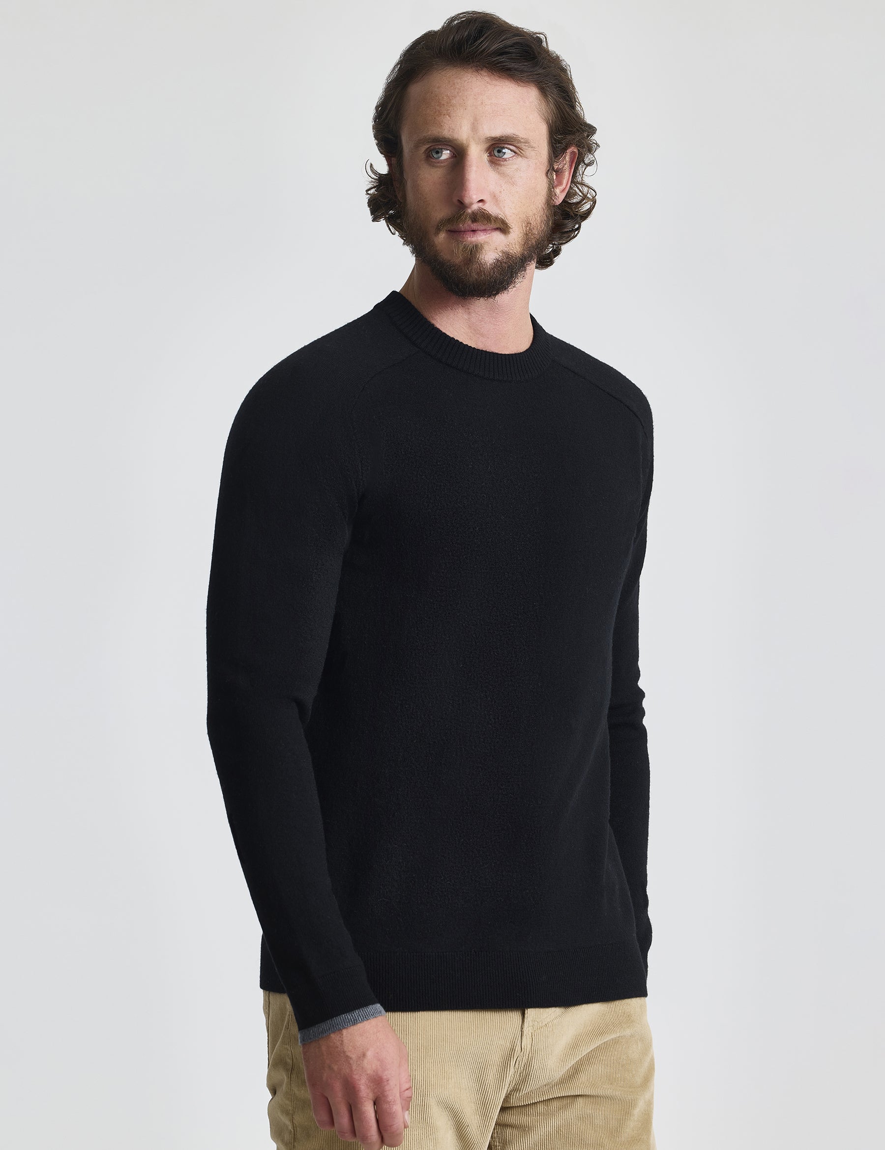 Angled front view of man wearing Corbin Sweater in Onyx Black from AETHER Apparel. 