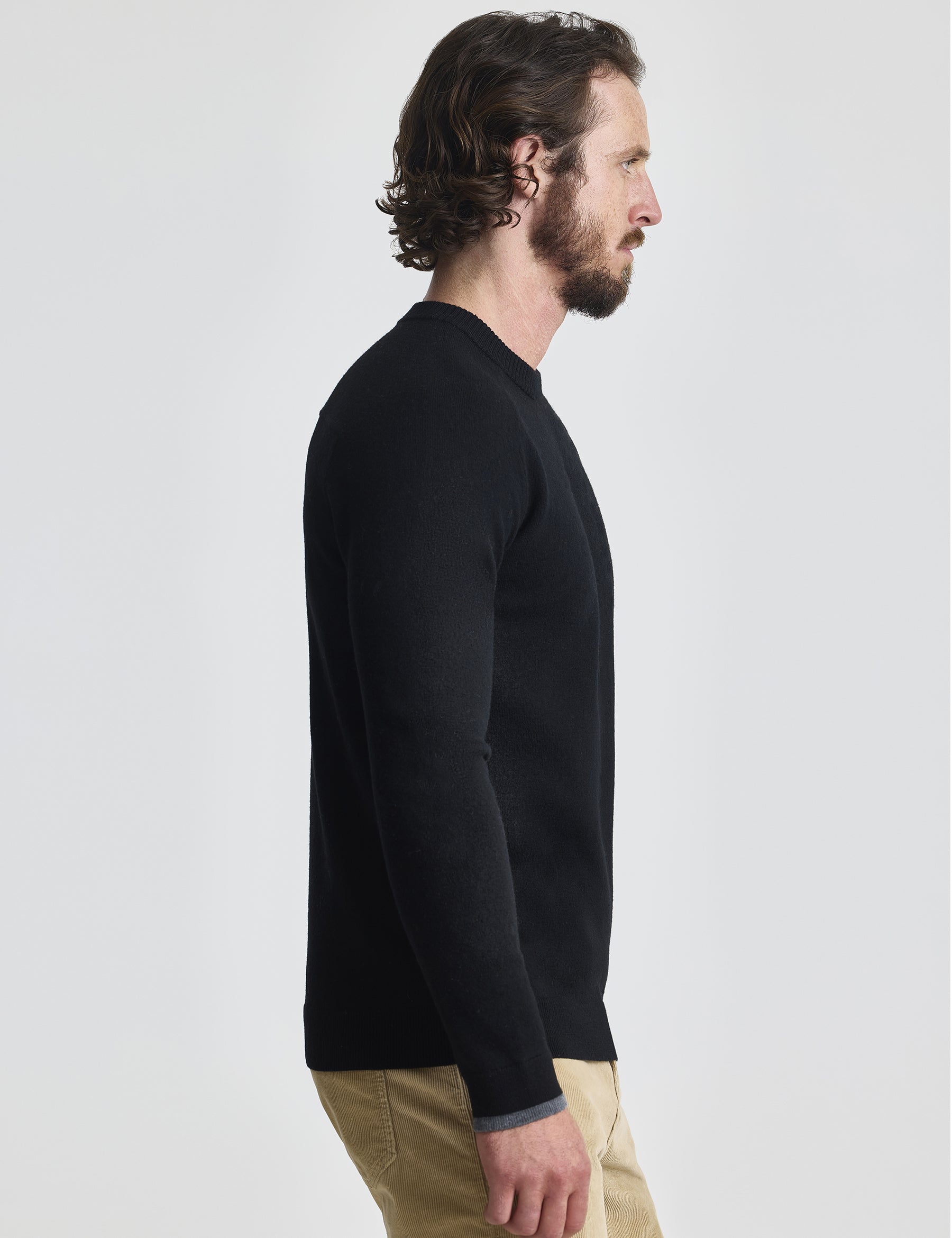 Right profile view of man wearing Corbin Sweater in Onyx Black from AETHER Apparel. 