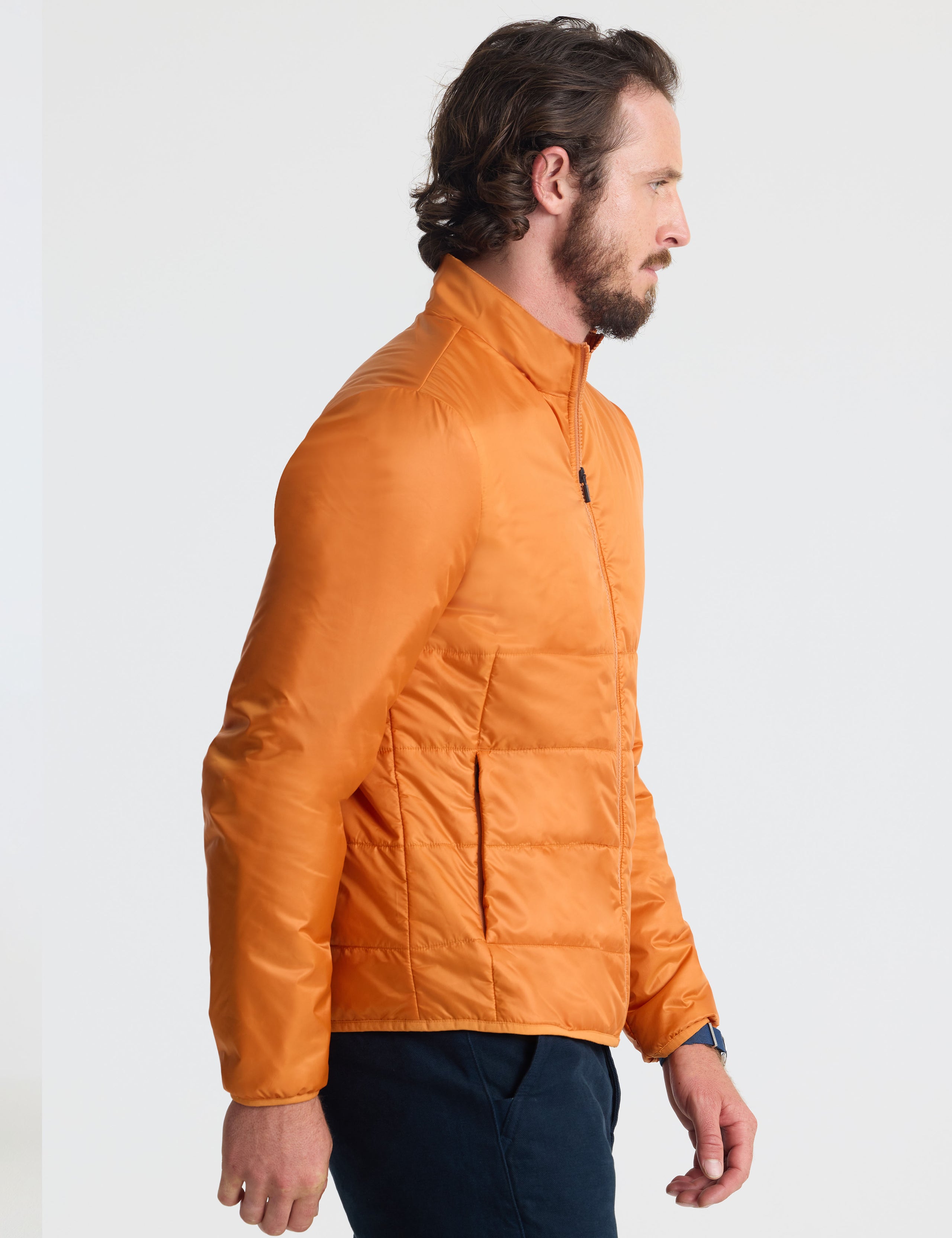 Right profile view of man wearing Eco Insulated Jacket in Autumn Orange from AETHER Apparel.