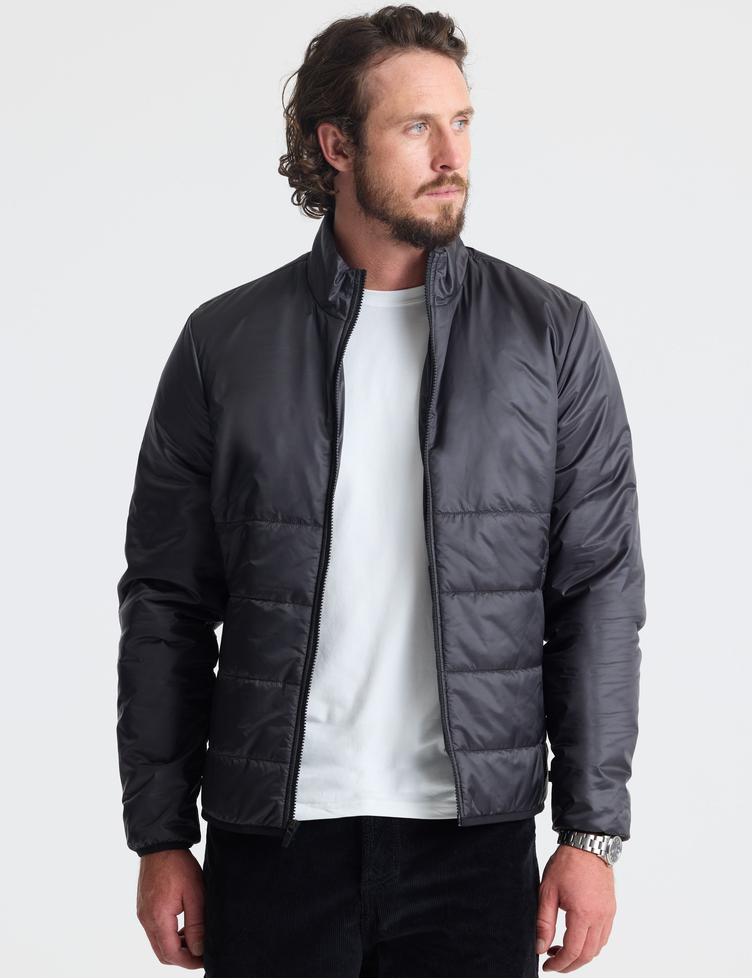 Front view of man wearing unzipped Eco Insulated Jacket in Onyx Black from AETHER Apparel.