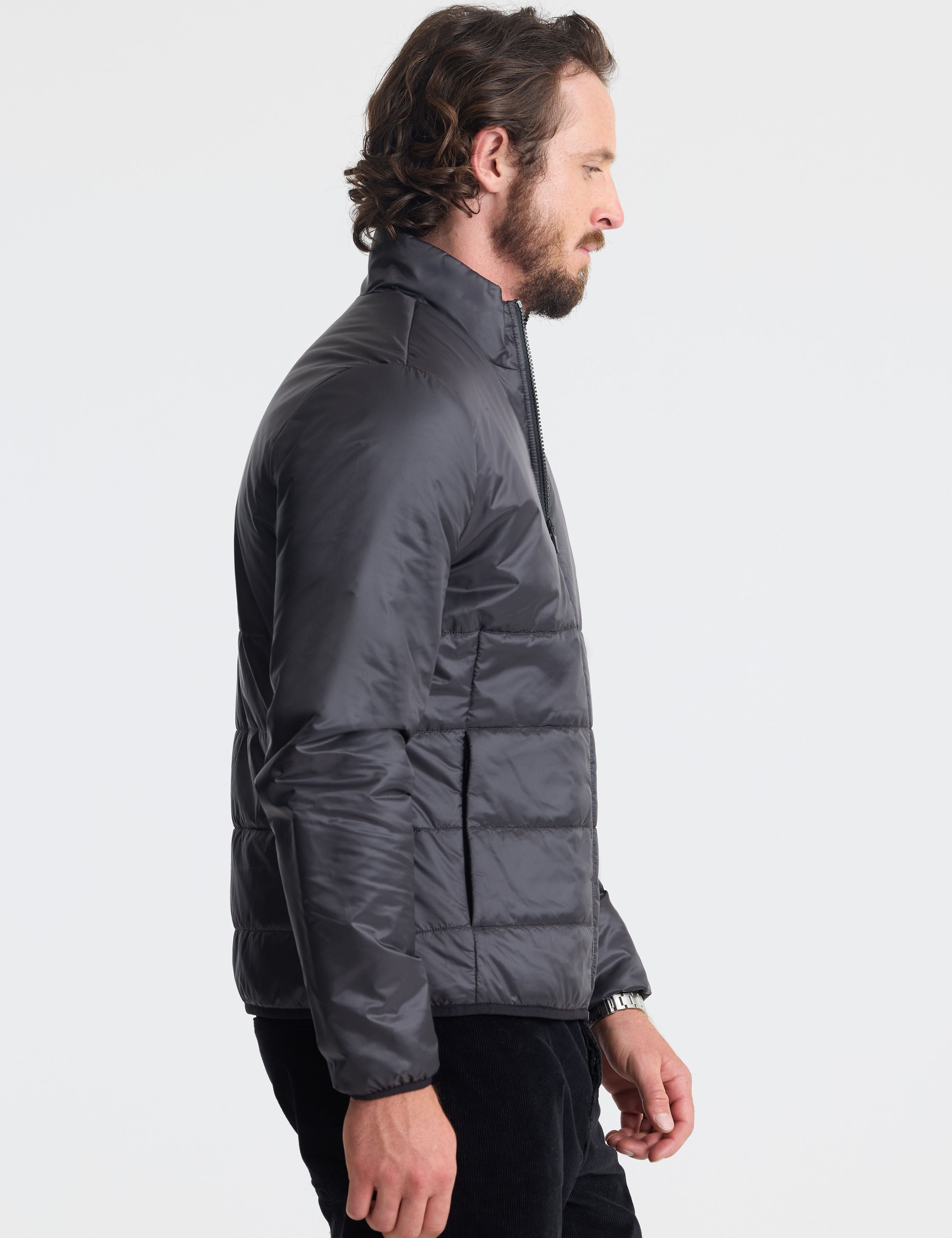 Right profile view of man wearing Eco Insulated Jacket in Onyx Black from AETHER Apparel.