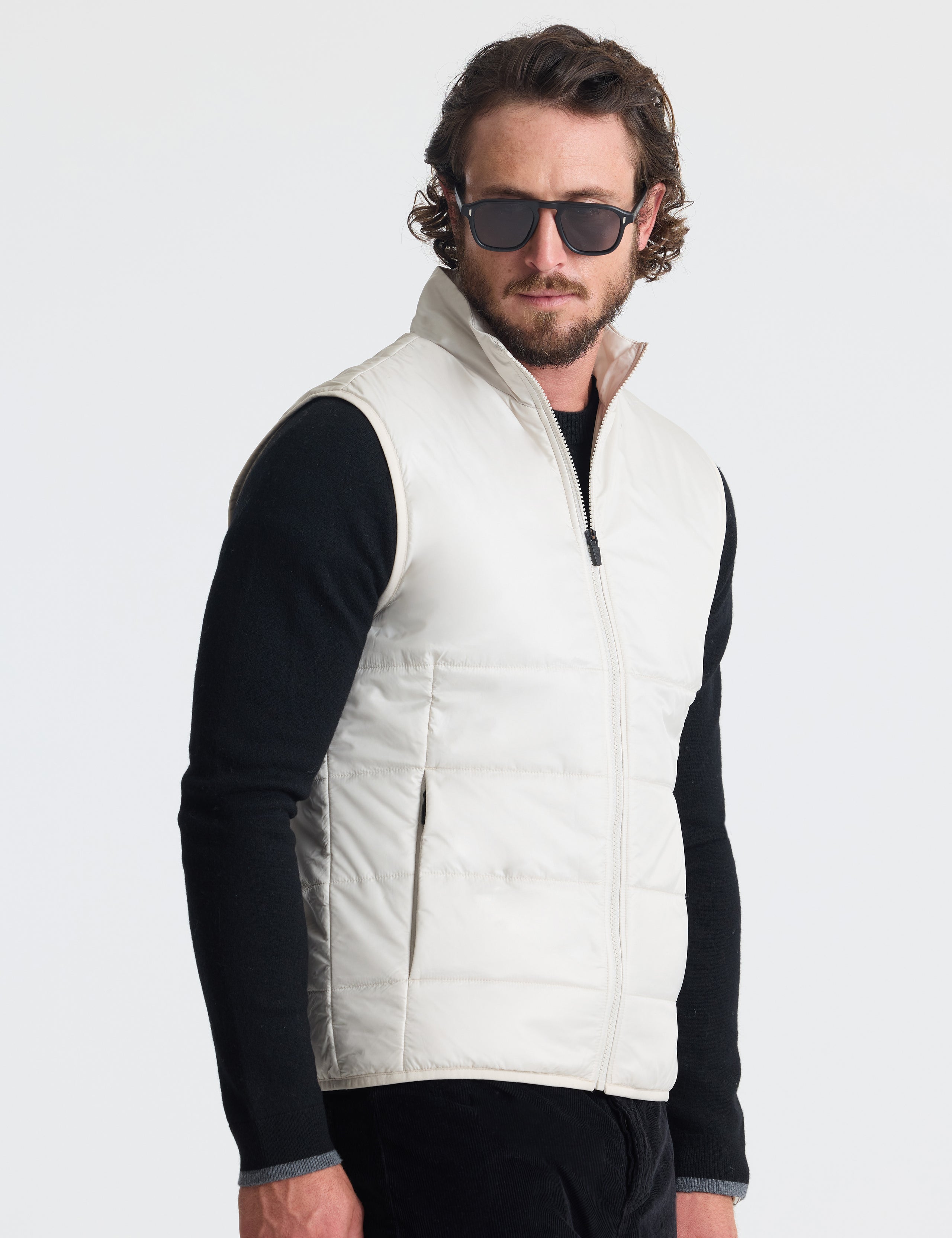 Angled view of man wearing Eco Insulated Vest in Bone white from AETHER Apparel.