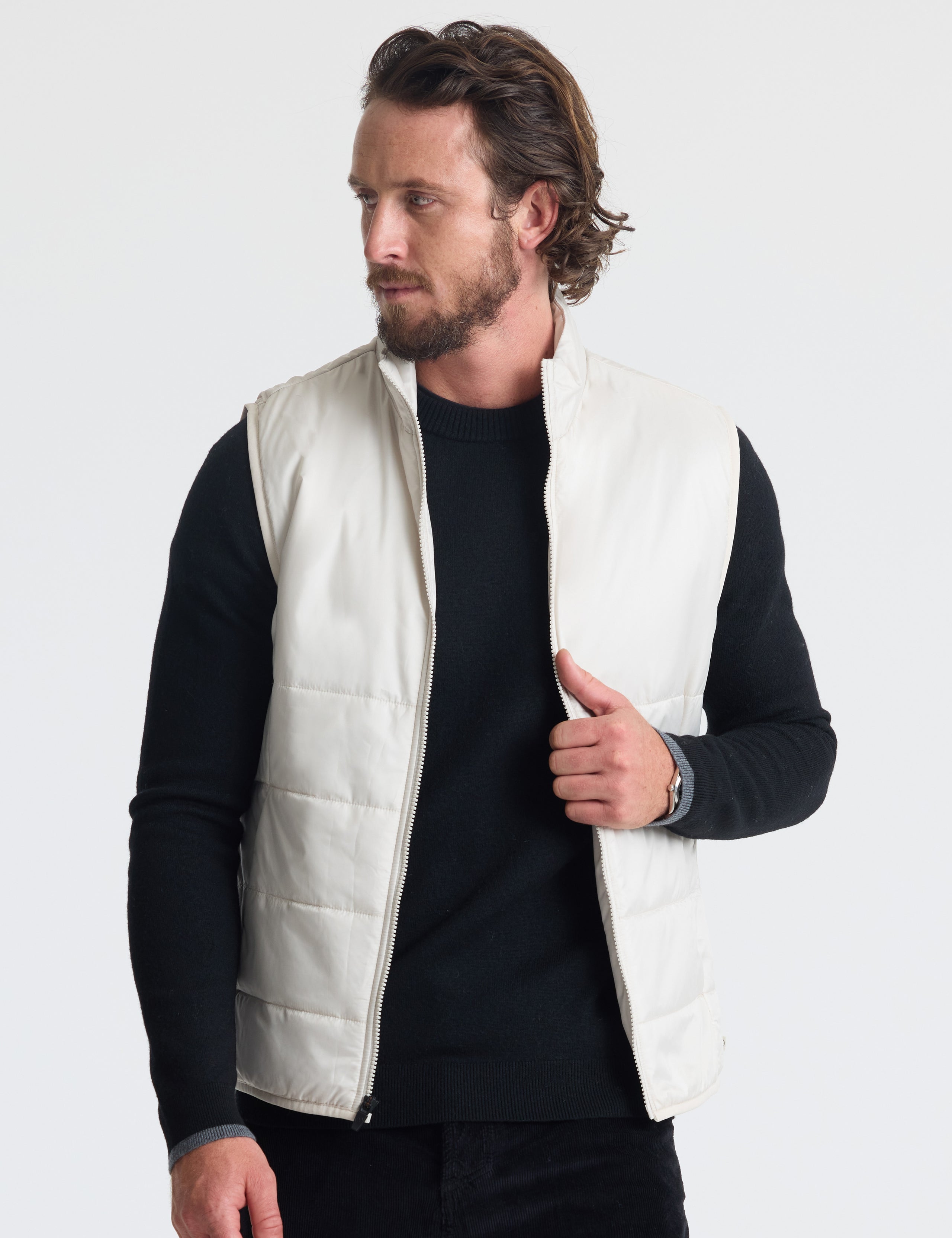 Front view of man wearing unzipped Eco Insulated Vest in Bone white from AETHER Apparel.