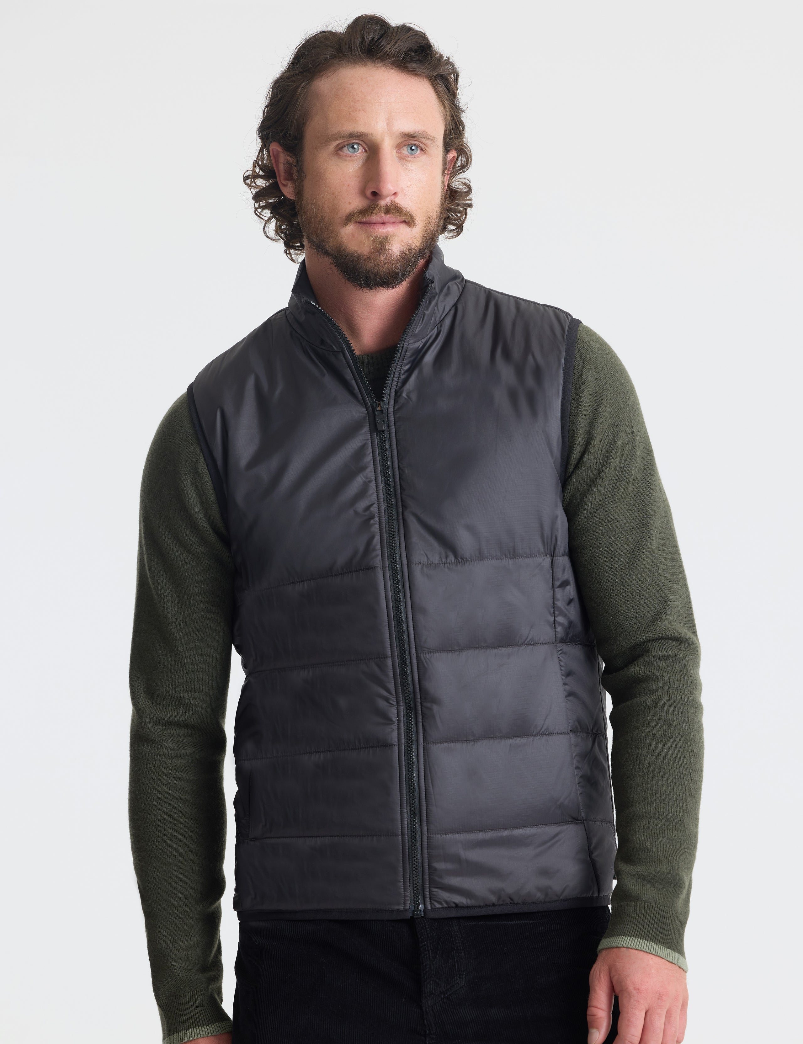 Front view of man wearing Eco Insulated Vest in Onyx Black from AETHER Apparel.