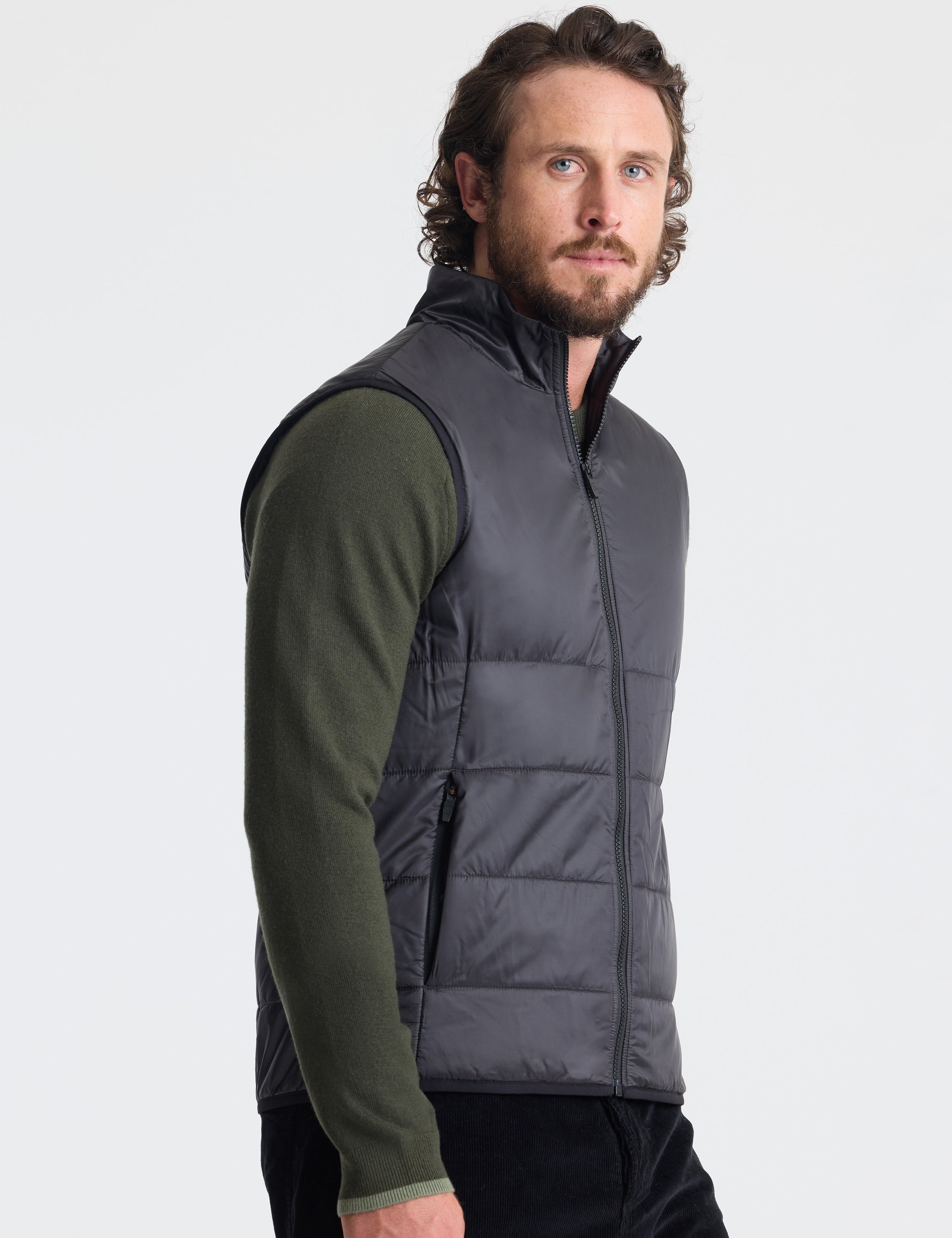 Right profile of man wearing Eco Insulated Vest in Onyx Black from AETHER Apparel.