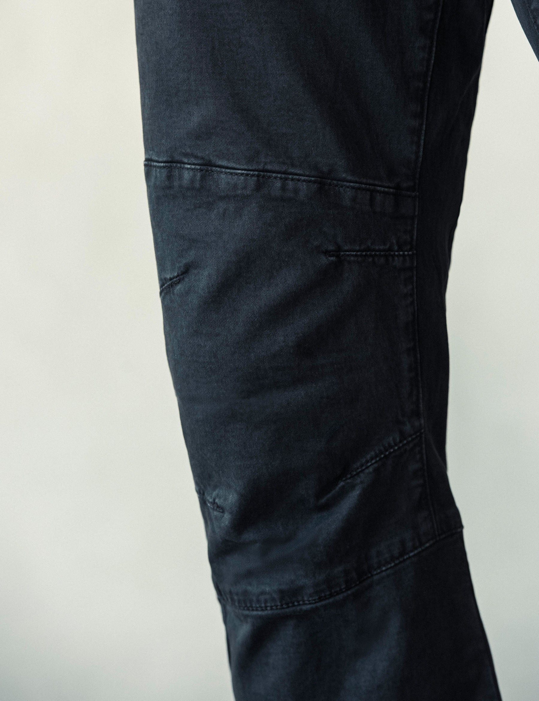 Closeup detailed view of the articulated knee panels on the Gabriel Articulated Chino Stretch pant in Tarmac Black from AETHER Apparel.