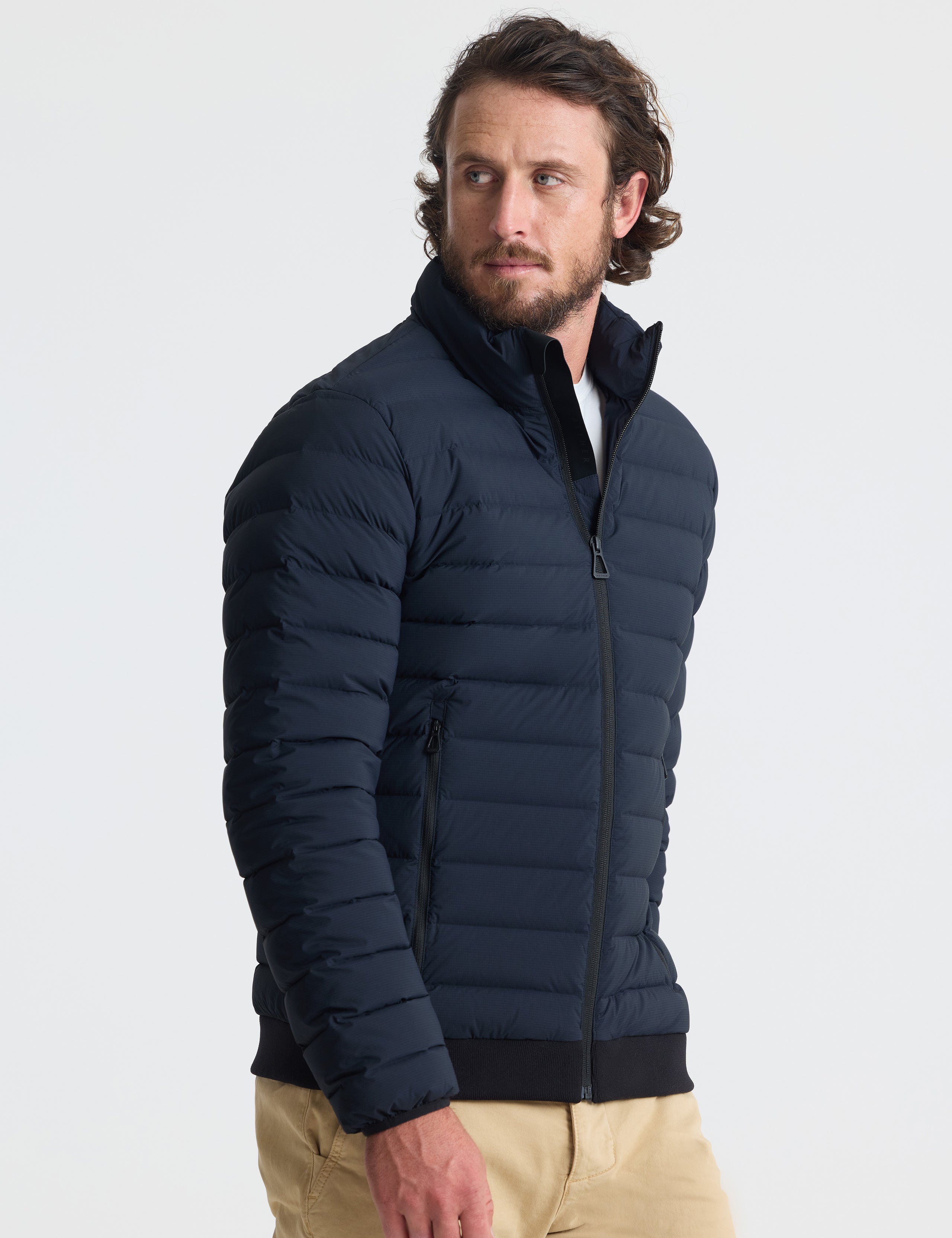 Angled view of man wearing Launch Jacket in Onyx Black from AETHER Apparel.