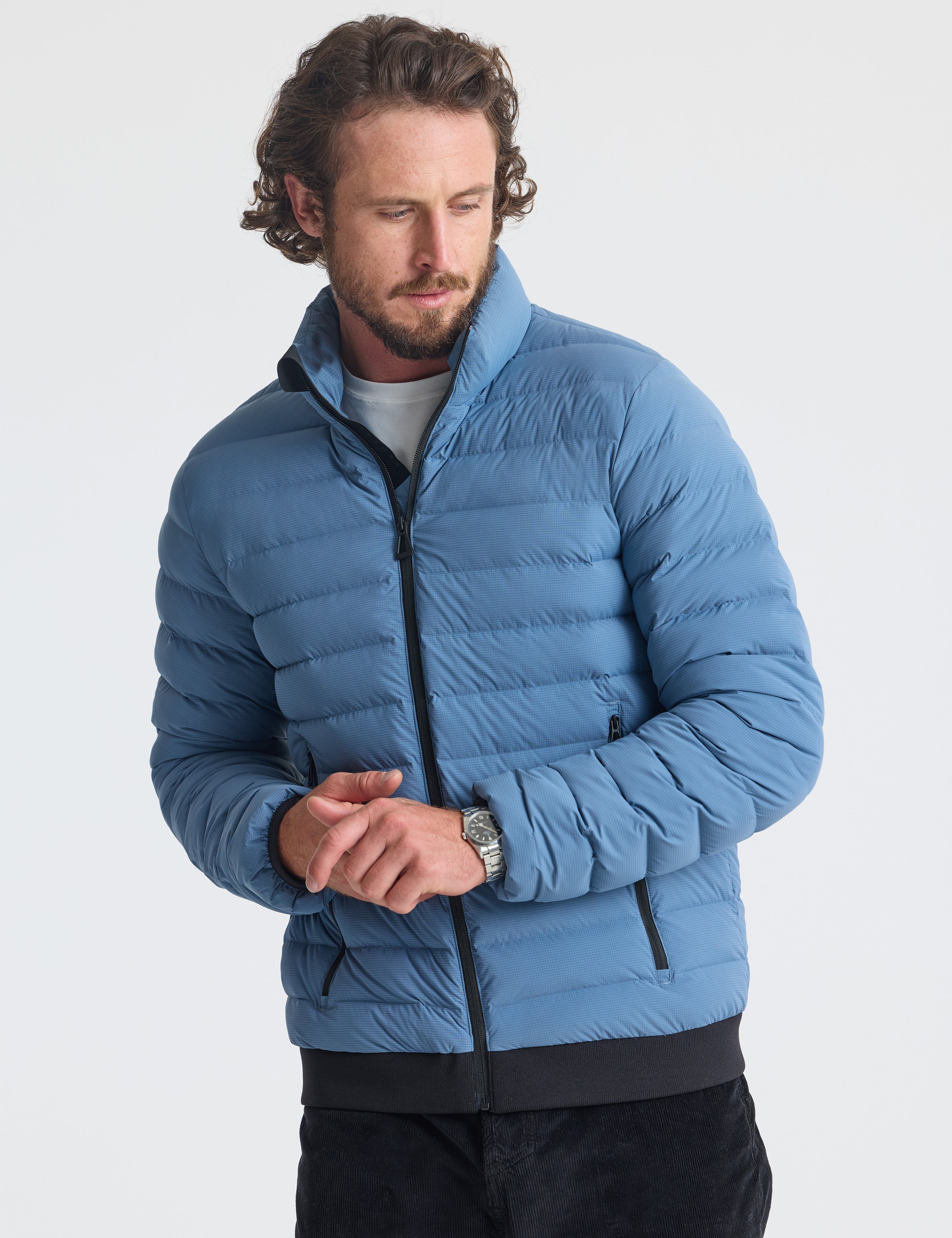 Front view of man wearing Prospect Packable Down Jacket in Portal Blue from AETHER Apparel.