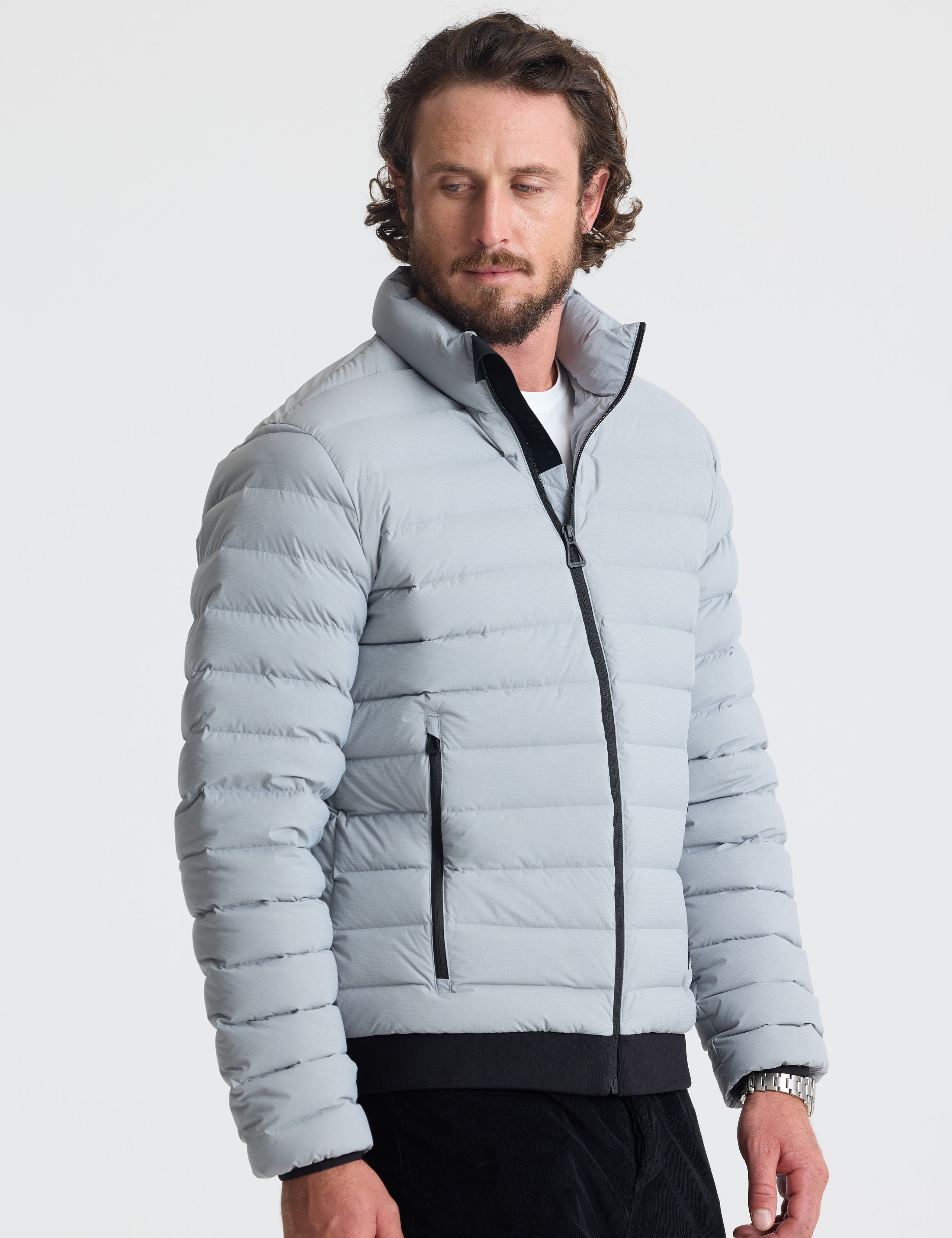 Angled view of man wearing Launch Jacket in Sky Grey from AETHER Apparel.