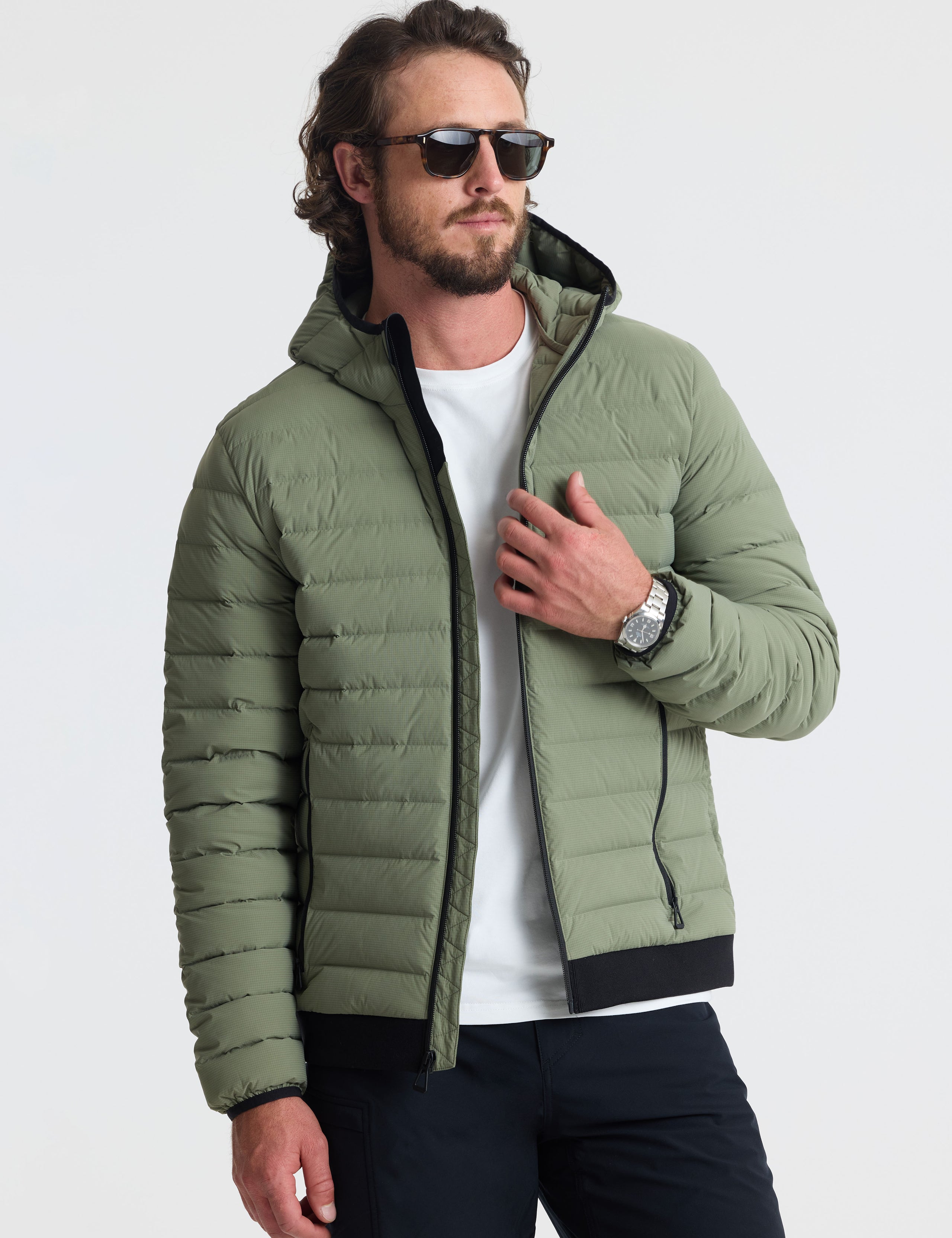 Front view of man wearing unzipped Launch Full-Zip Hooded Jacket in Fern Green from AETHER Apparel.