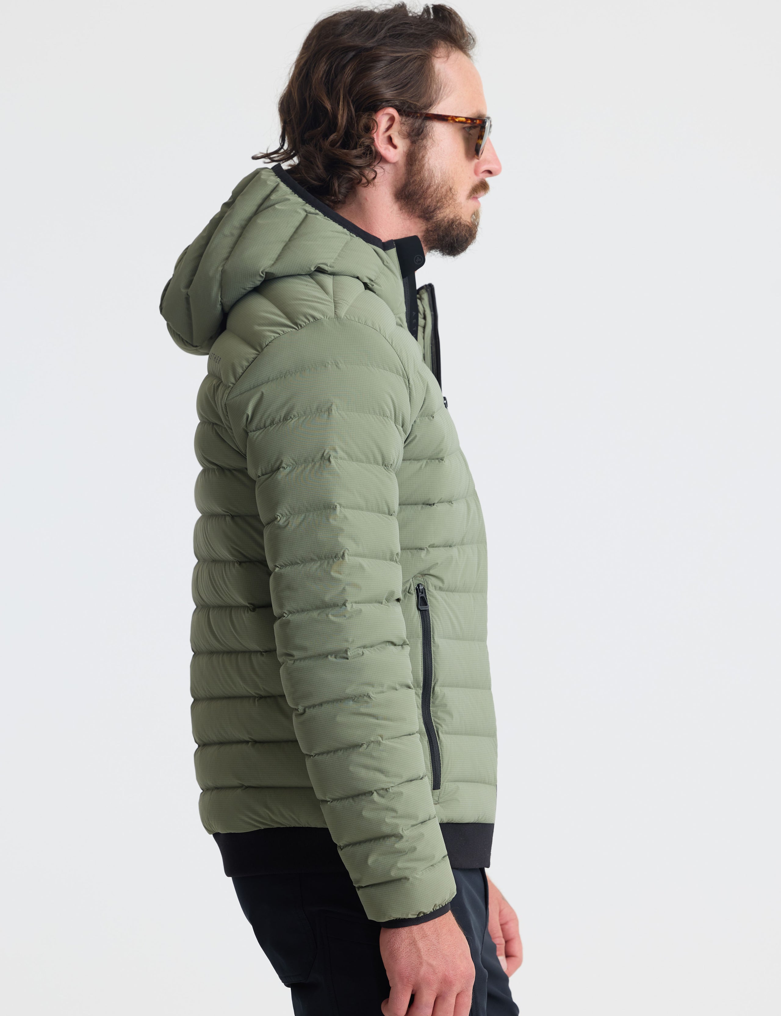 Right profile view of man wearing Launch Full-Zip Hooded Jacket in Fern Green from AETHER Apparel.