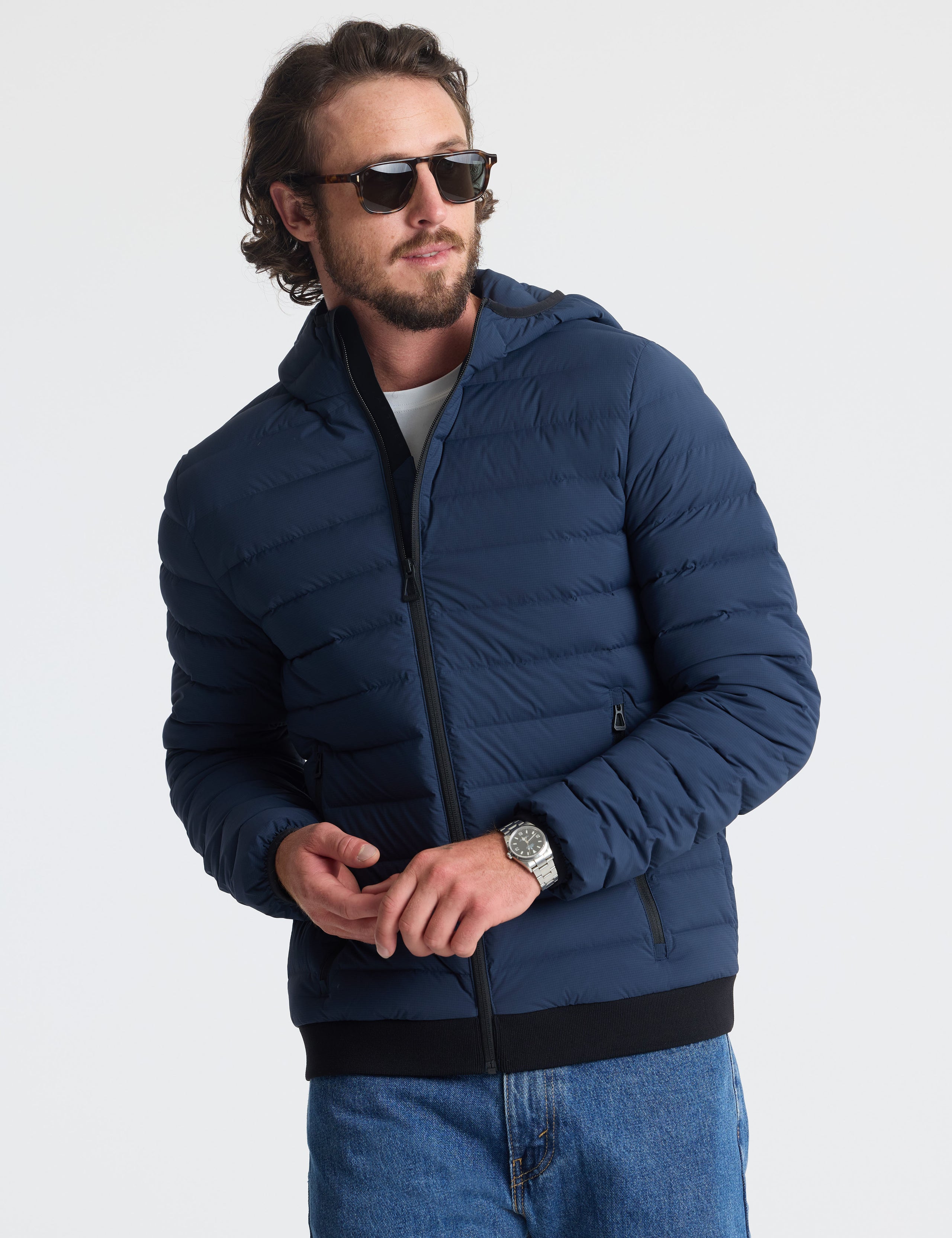 Front upper body view of man wearing Launch Full-Zip Hooded Jacket in Total Eclipse dark blue from AETHER Apparel.