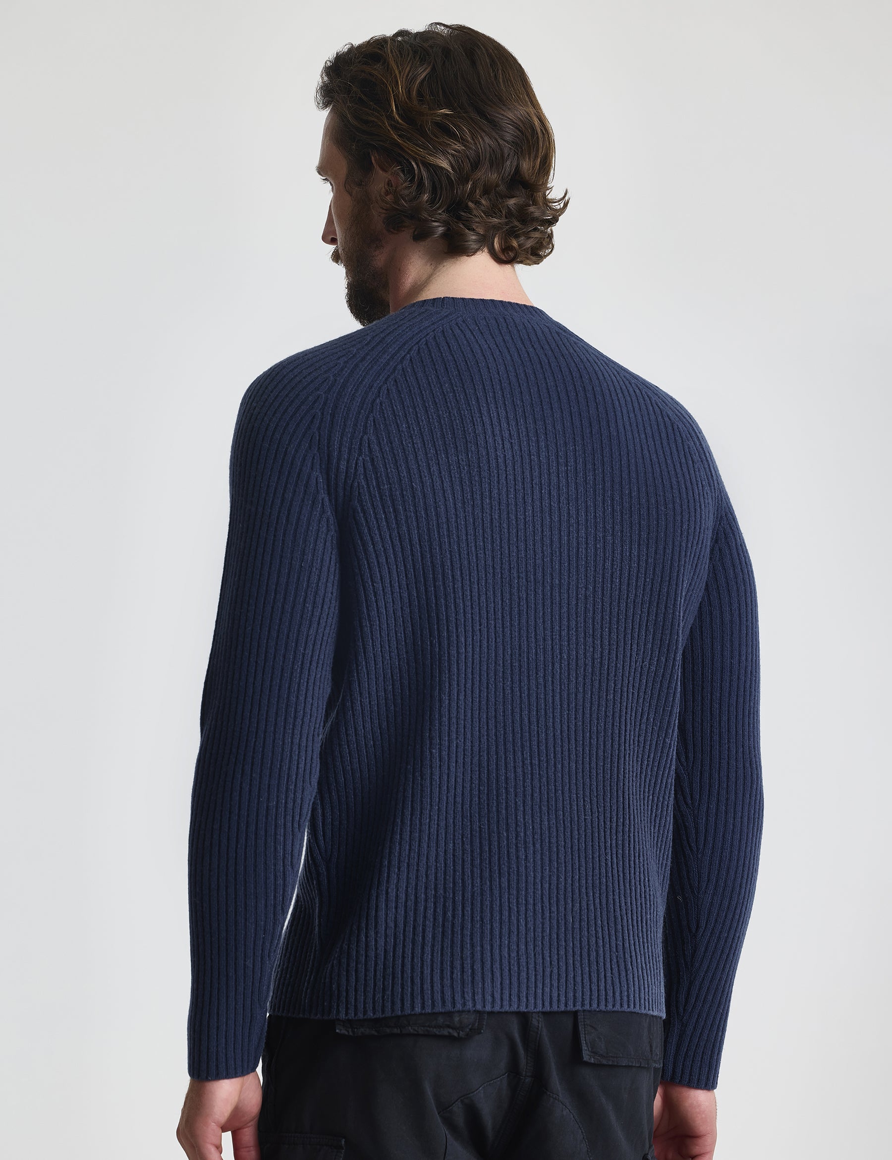 Rear view of man wearing Lyon Sweater in Total Eclipse dark blue from AETHER Apparel.
