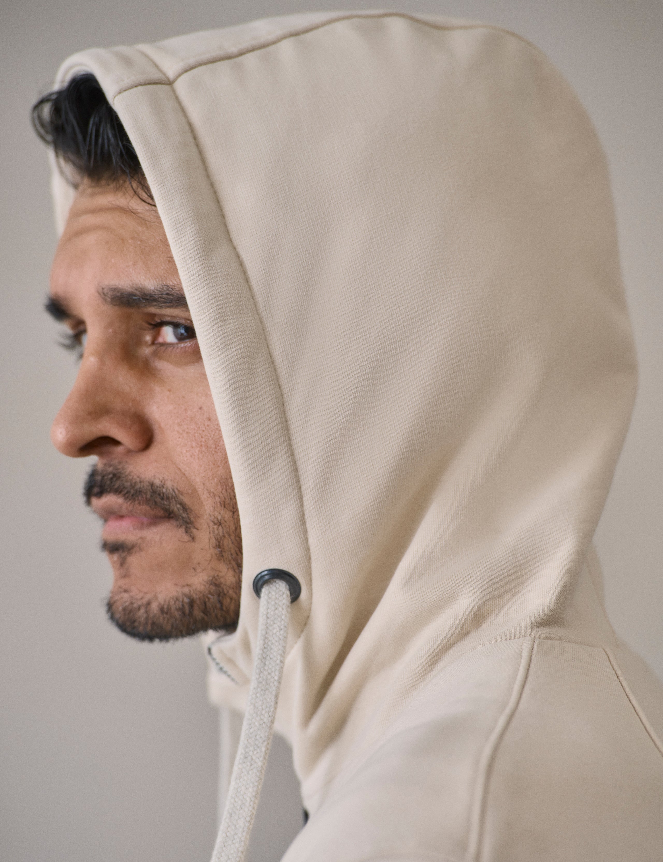 Closeup detailed view the main zipper-secured center-front closure on the Monte Full-Zip Hoodie in Bone white from AETHER Apparel.
