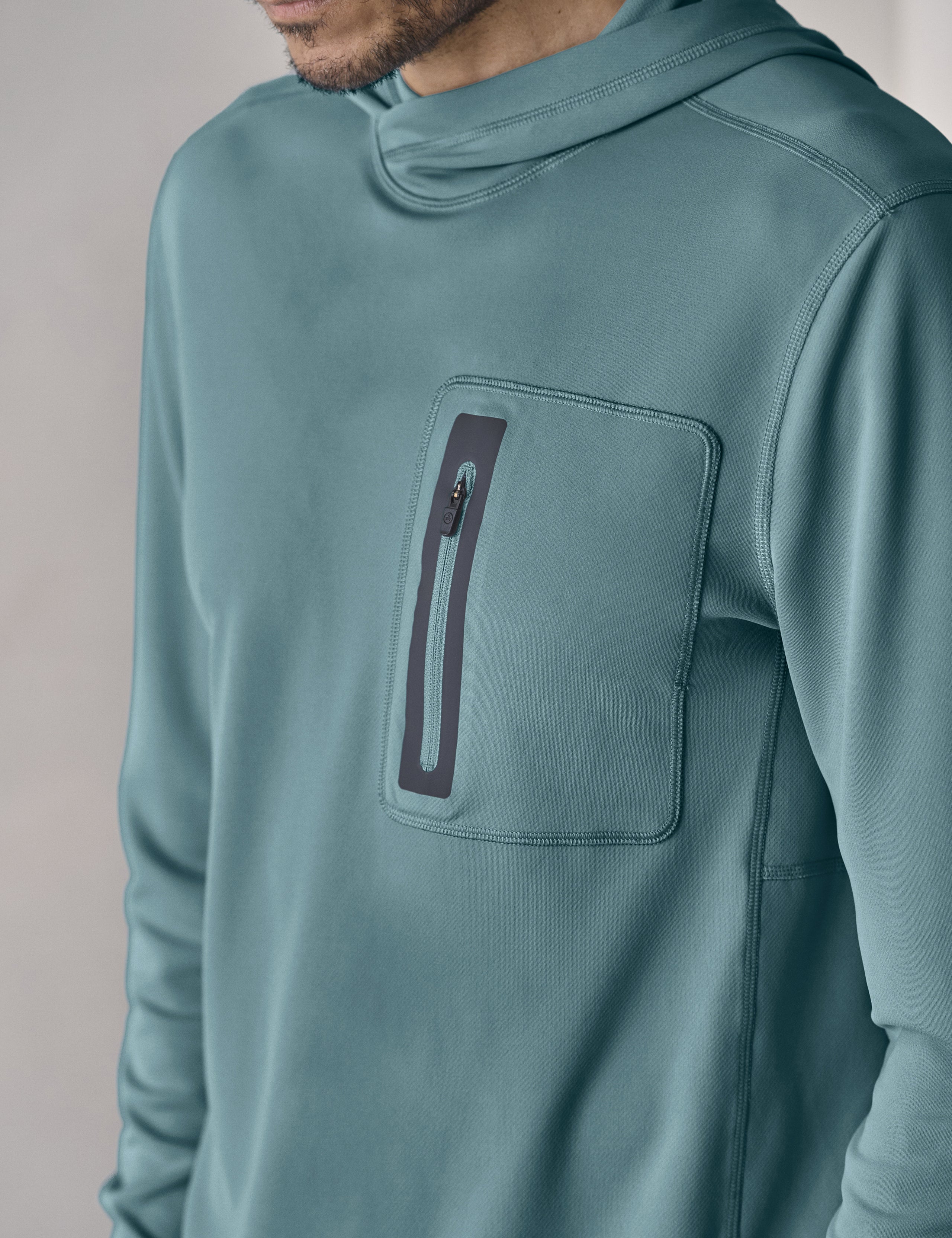 Closeup front 3/4 upper-body view of man wearing Pacific Hooded Sun Shirt in Aqua Blue from AETHER Apparel.