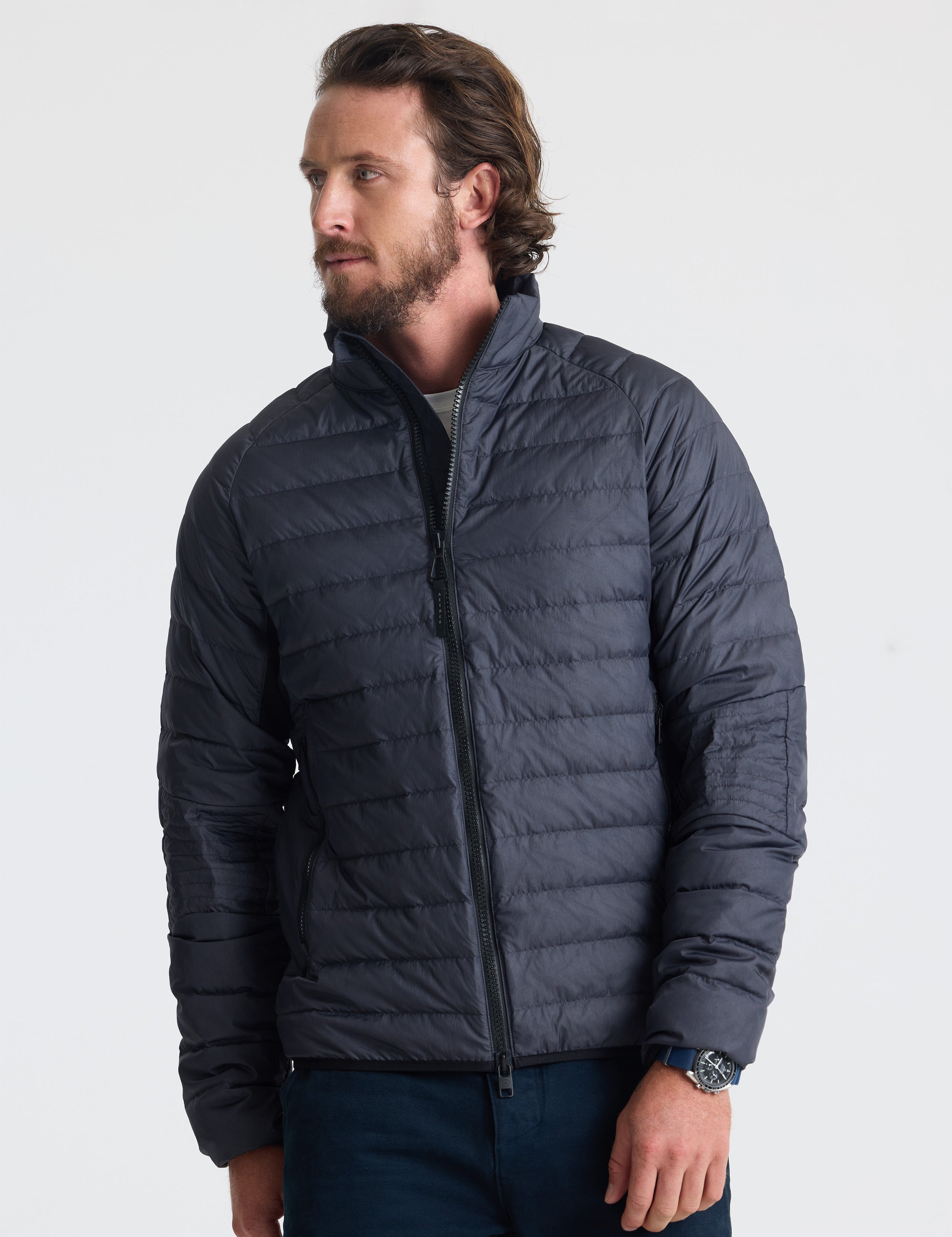 Front view of man wearing Prospect Packable Down Jacket in Onyx Black from AETHER Apparel.