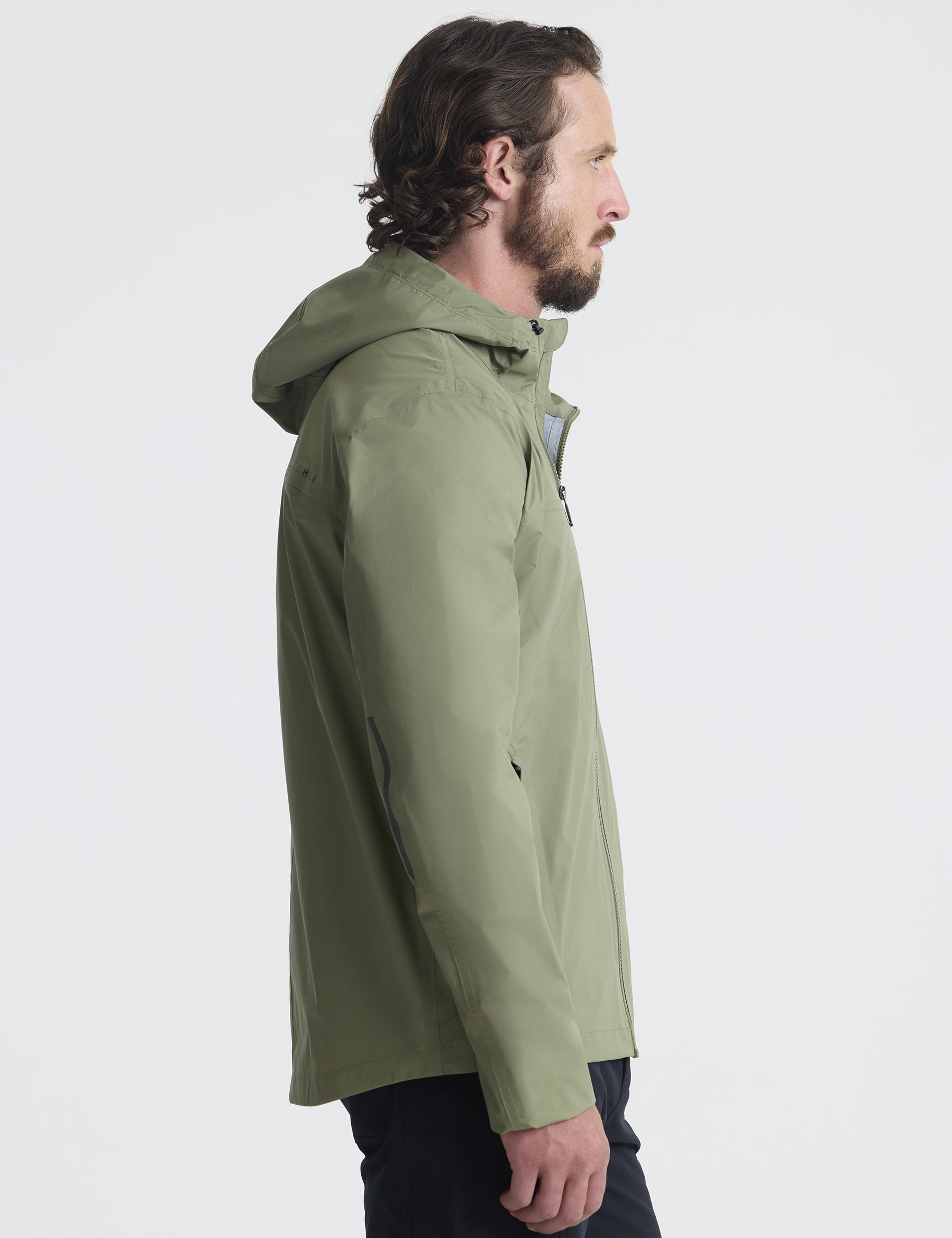 Right profile view of man wearing Storm All-Weather Jacket in Fern Green from AETHER Apparel.