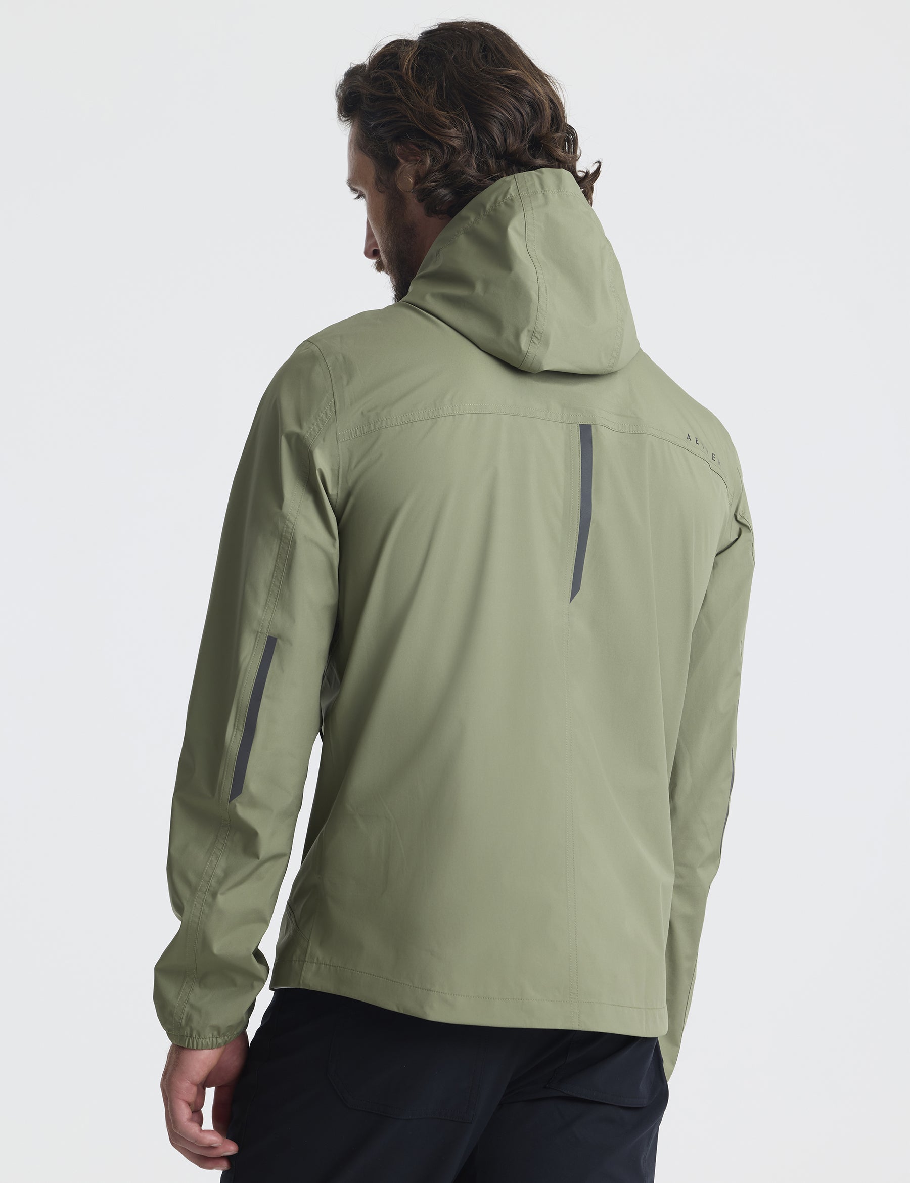 Rear view of man wearing Storm All-Weather Jacket in Fern Green from AETHER Apparel.