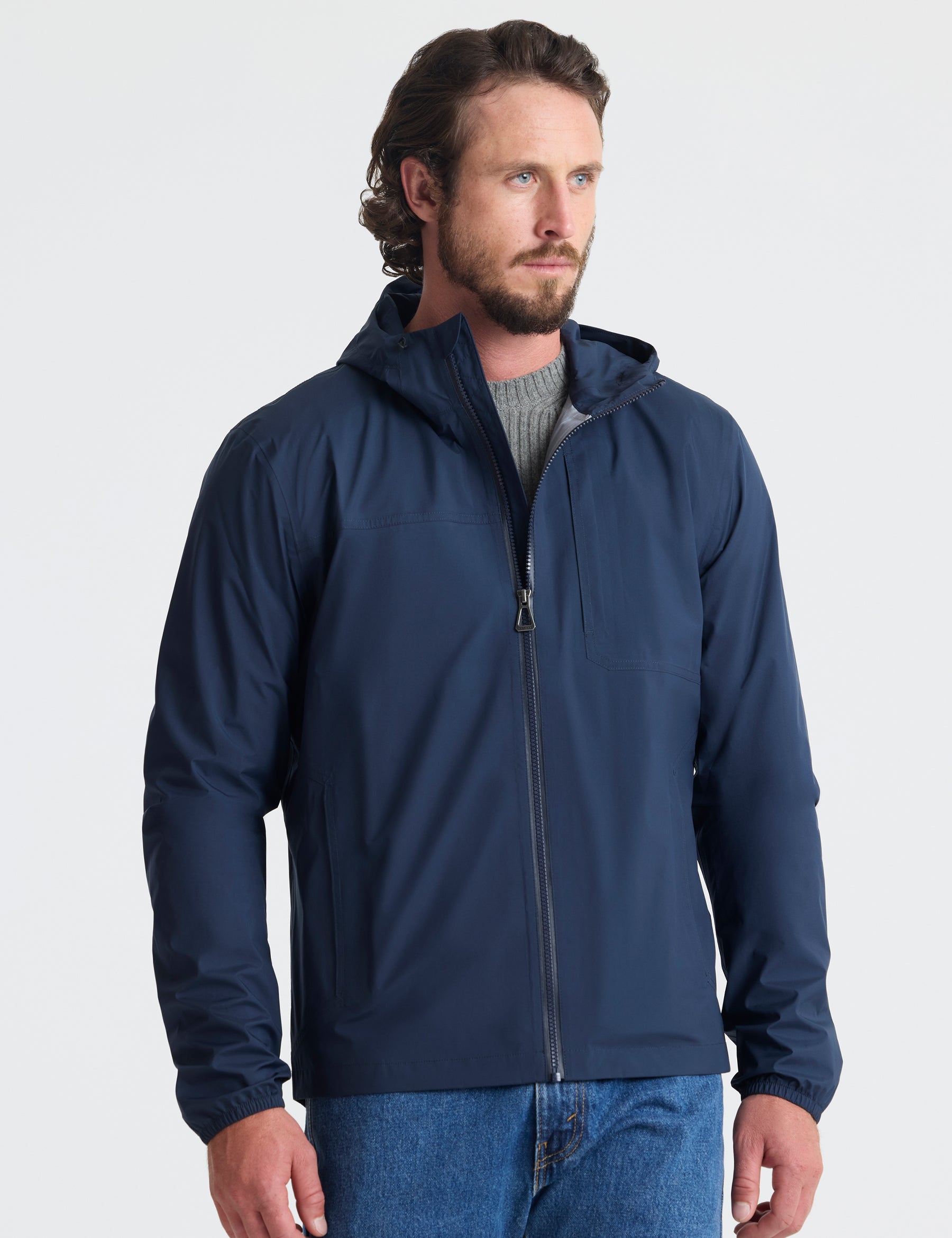 Front view of man wearing Storm All-Weather Jacket in Total Eclipse dark blue from AETHER Apparel.