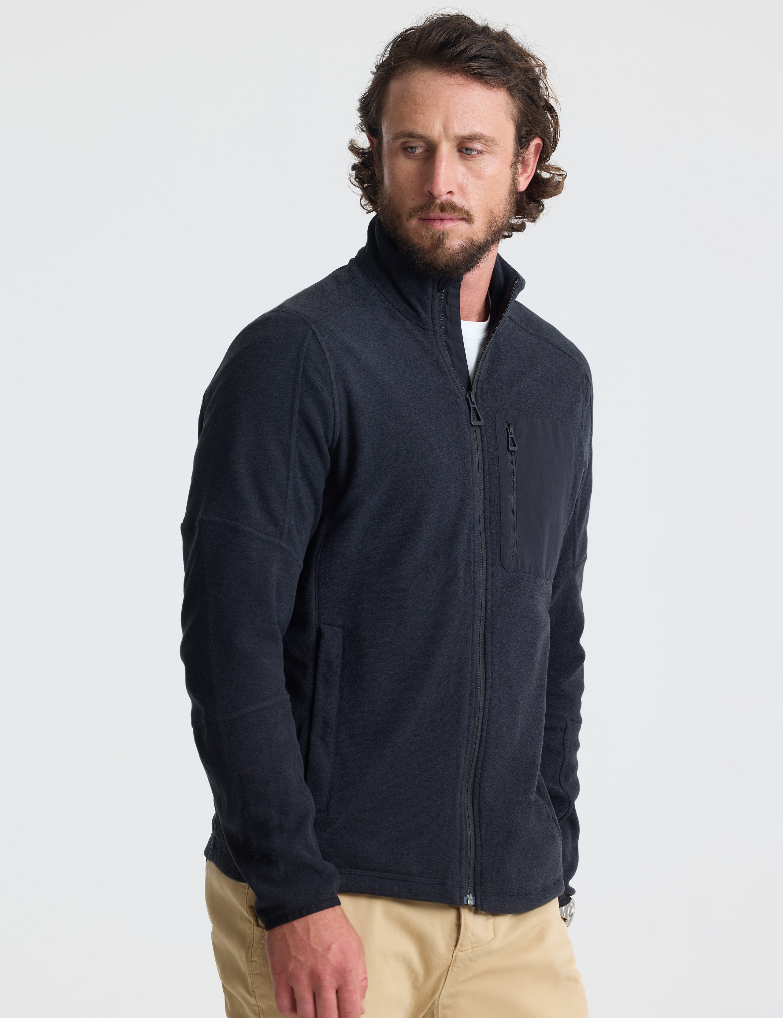 Angled view of man wearing Sutherlin Full-Zip in Onyx Black from AETHER Apparel.