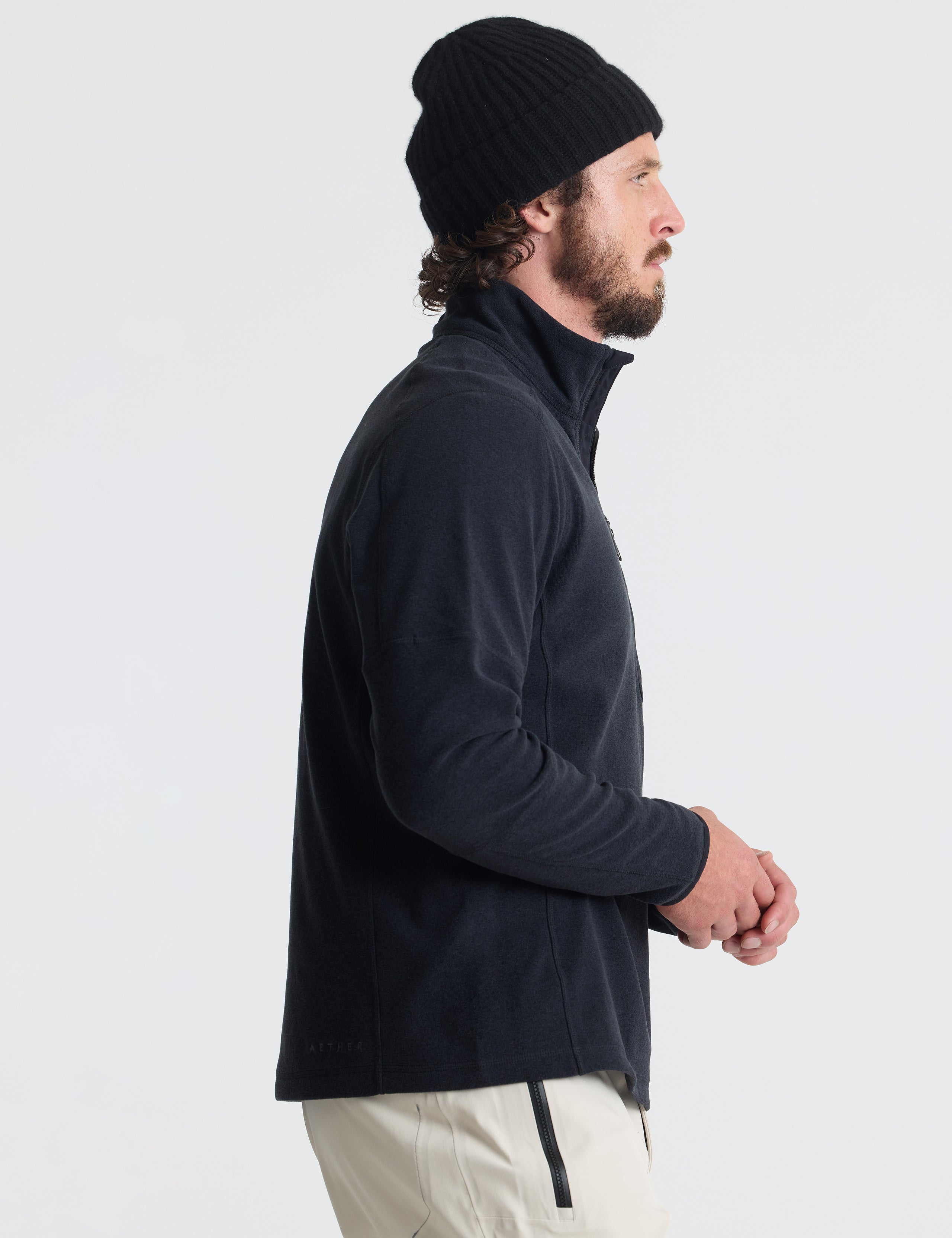 Right profile of man wearing Sutherlin Half-Zip in Onyx Black from AETHER Apparel.