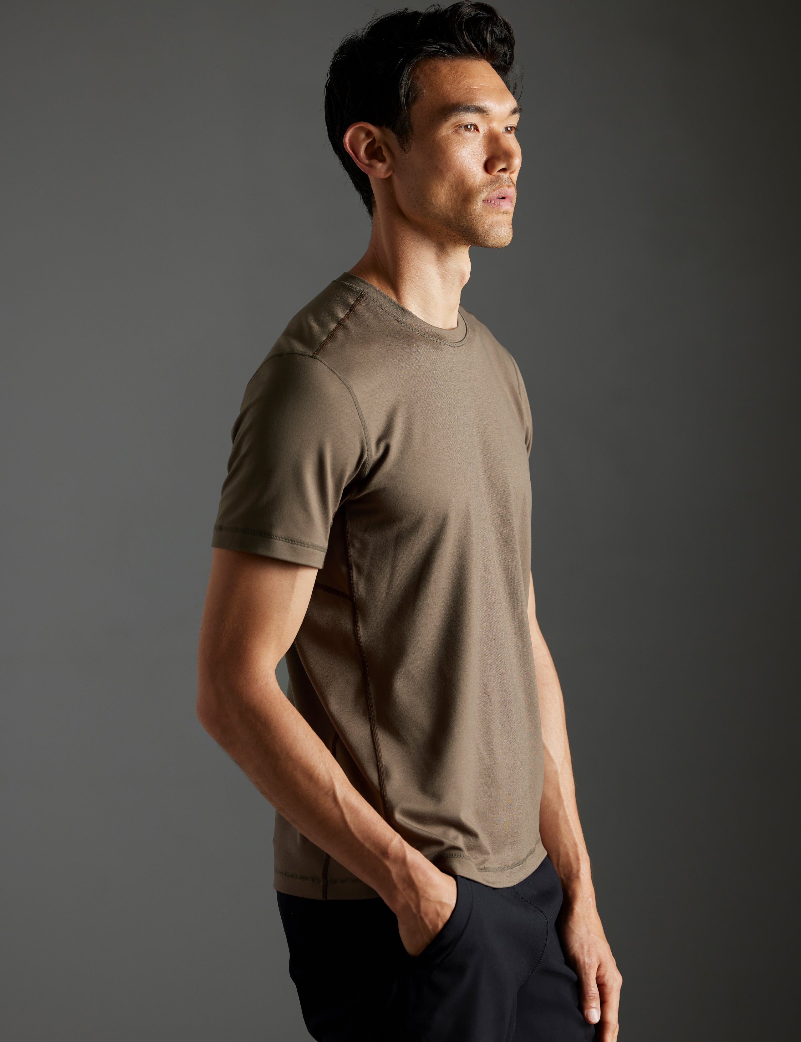 Front 3/4 body view of man wearing Trek Articulated Tee in Cadet green from AETHER Apparel.