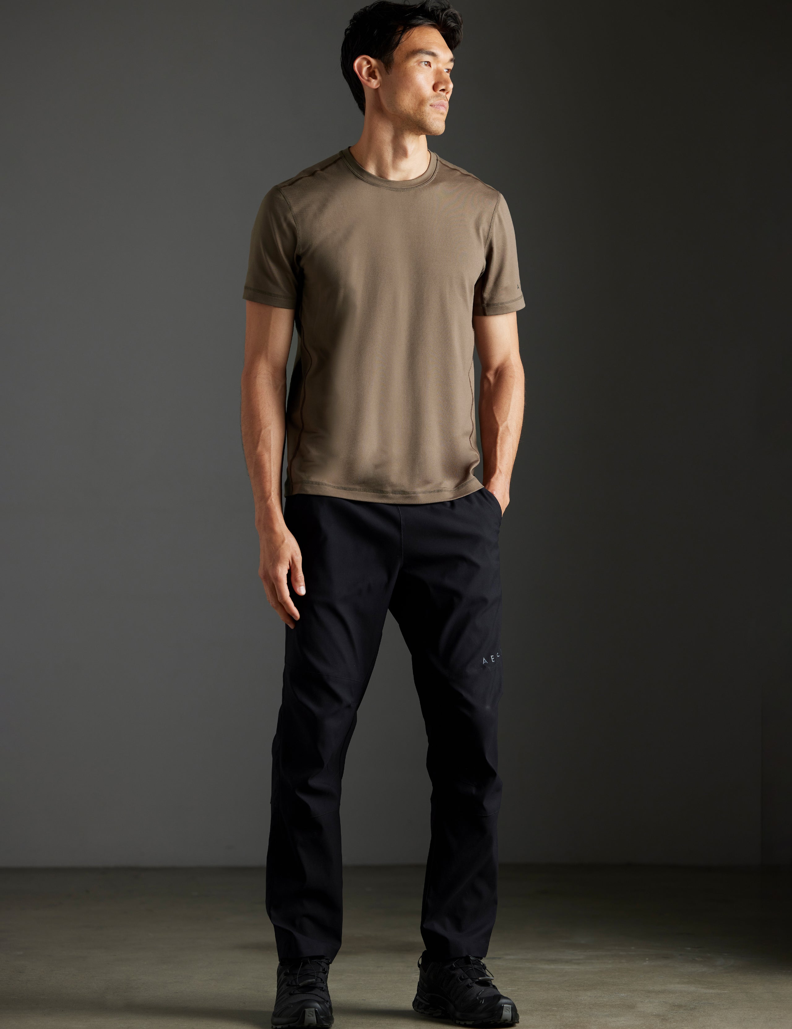 Front full-body view of man wearing Trek Articulated Tee in Cadet green from AETHER Apparel.