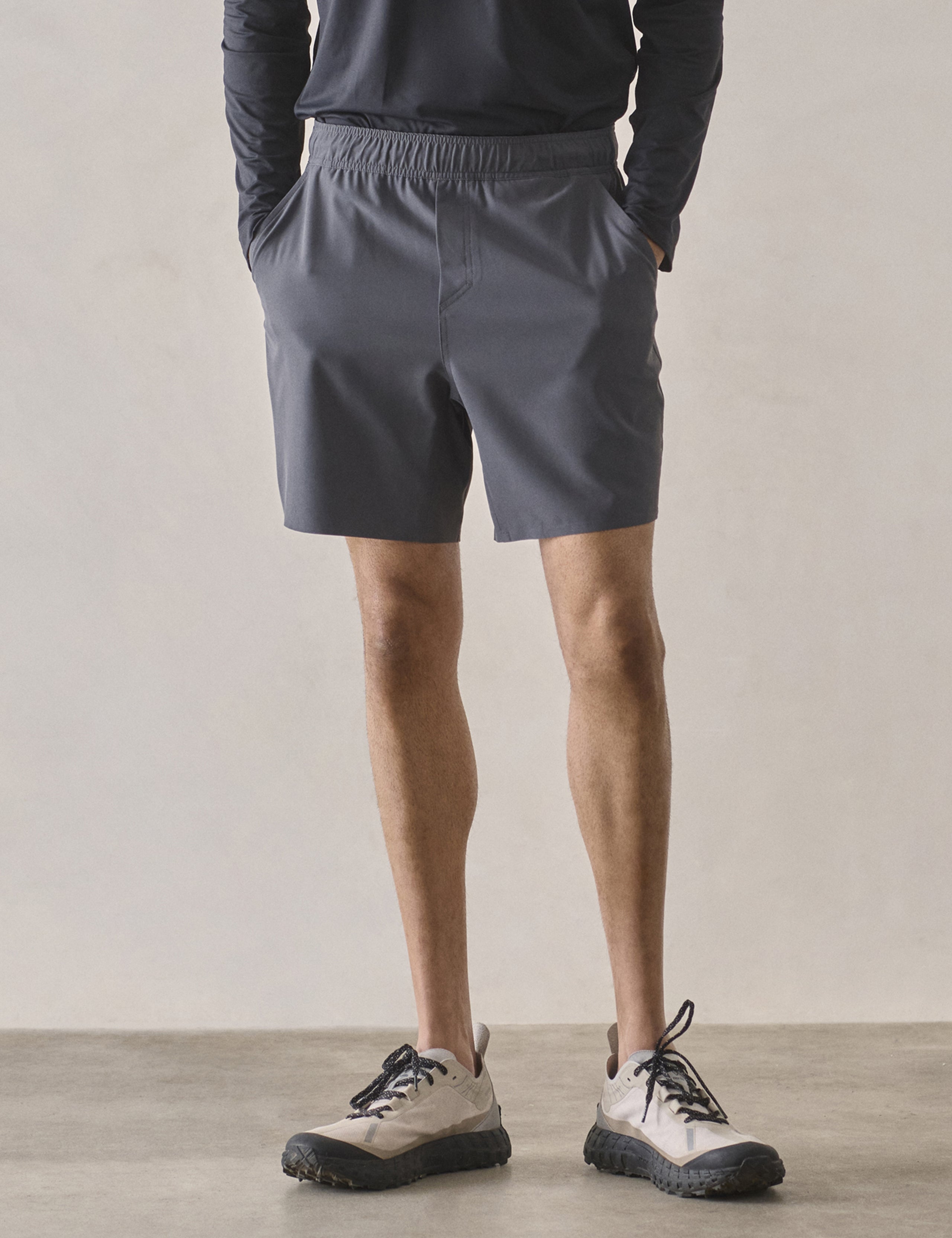 Front lower-body view of man wearing Rogue Hybrid Short in Graphite from AETHER Apparel.